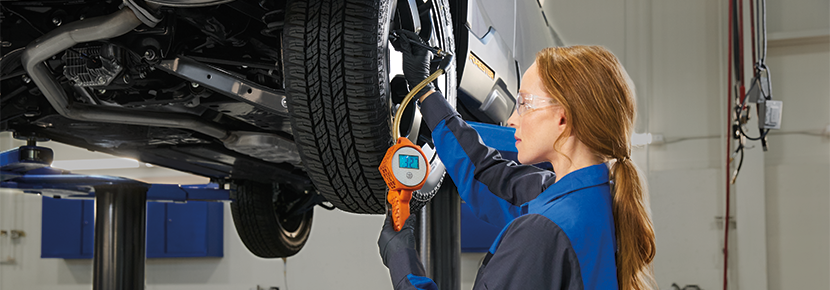 A Subaru technician checking tire pressure. | Tindol Subaru in Gastonia NC