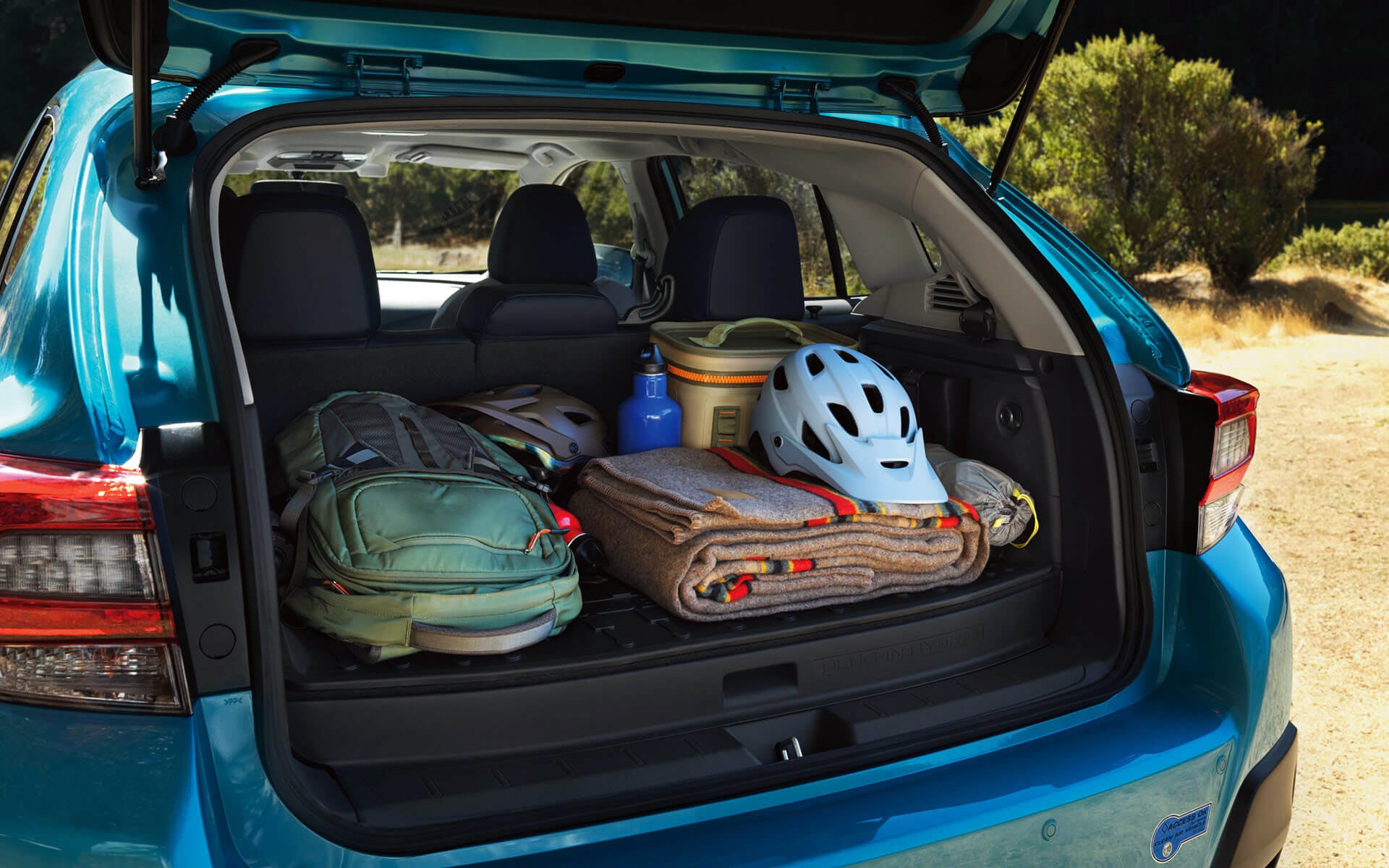 A backpack, blanket, and bike helmet in the rear cargo area of a Crosstrek Hybrid | Tindol Subaru in Gastonia NC