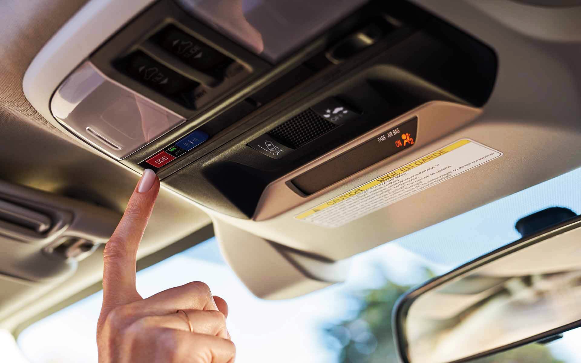 A finger pressing the Crosstrek Hybrid's SOS emergency assistance button | Tindol Subaru in Gastonia NC